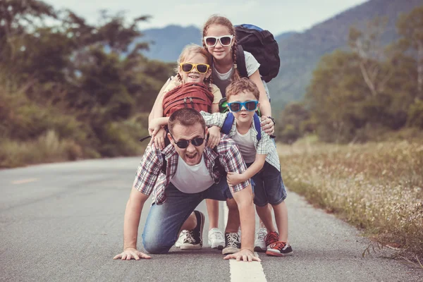 Father and children walking on the road at the day time. — Stock Photo, Image