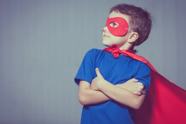 Glückliches kleines Kind spielt Superhelden. — Stockfoto