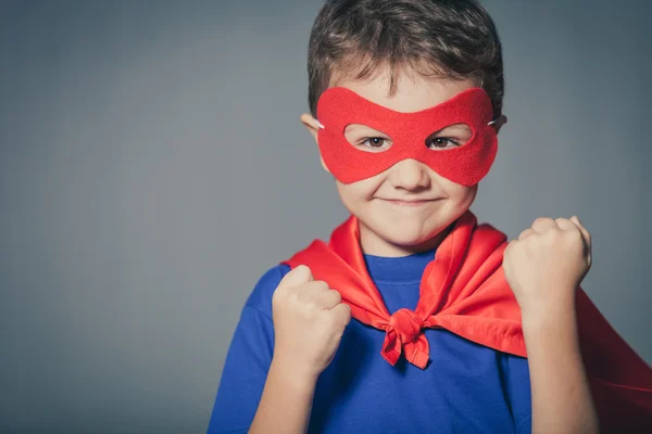 Glückliches kleines Kind spielt Superhelden. — Stockfoto