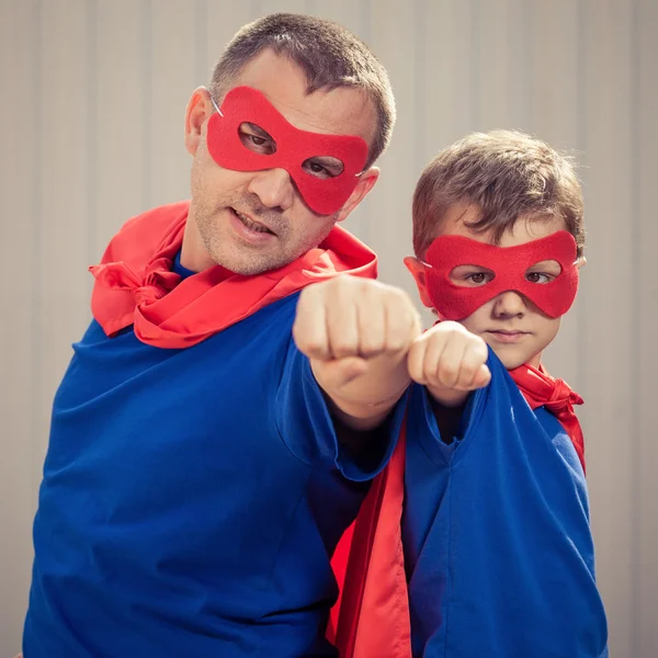 Vater und Sohn spielen tagsüber im Freien Superhelden. — Stockfoto