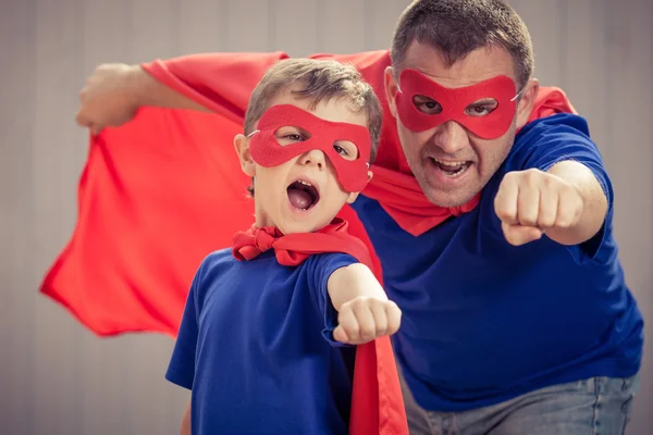 Vater und Sohn spielen tagsüber im Freien Superhelden. — Stockfoto