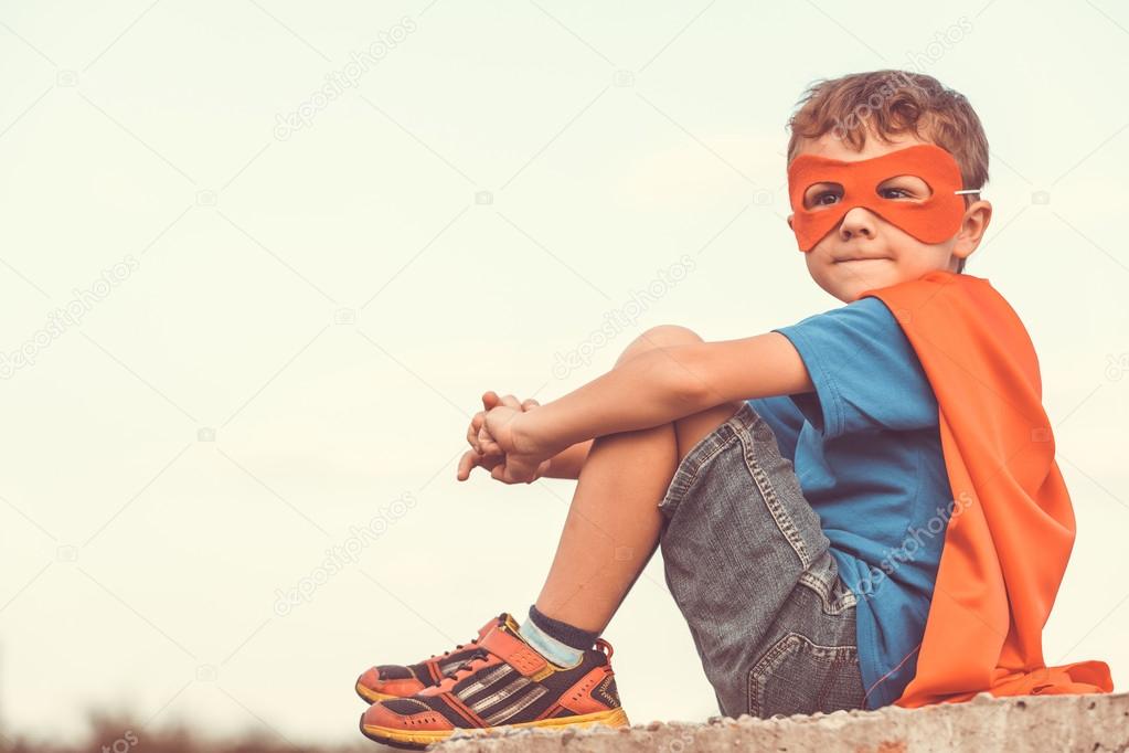 Happy little child playing superhero.