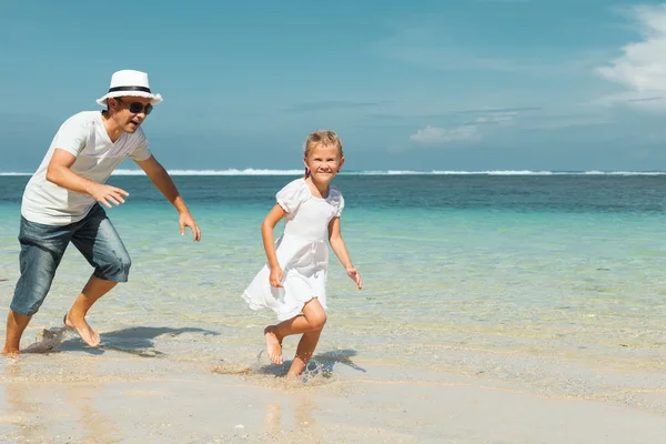 Vader en dochter op het strand uitgevoerd op het moment van de dag — Stockfoto