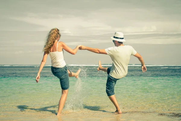 Gelukkige paar spelen op het strand op het moment van de dag해변에서 낮 시간에 재생 하는 행복 한 커플 — Stockfoto