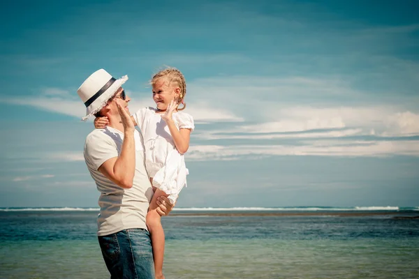 Pai e filha brincando na praia no dia — Fotografia de Stock
