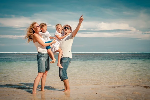 Счастливая семья стоит на пляже в дневное время — стоковое фото