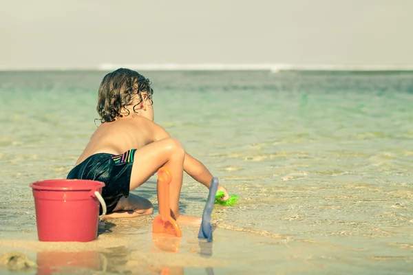 Mały chłopiec gra na plaży w czasie dnia — Zdjęcie stockowe