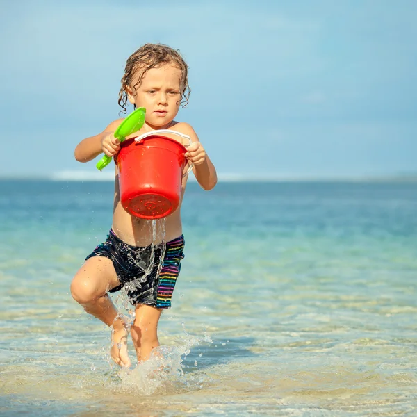 Malý chlapec hraje na pláži v denní době — Stock fotografie