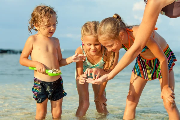 Glückliche Kinder, die tagsüber am Strand spielen — Stockfoto