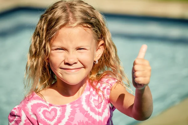 Liten flicka sitter nära poolen — Stockfoto