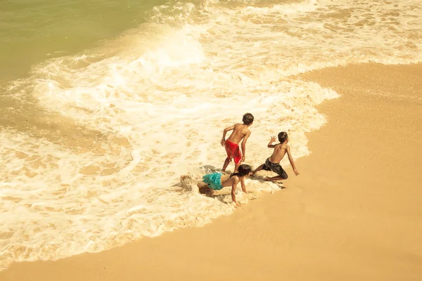 Glada barn som leker på stranden på dagarna — Stockfoto