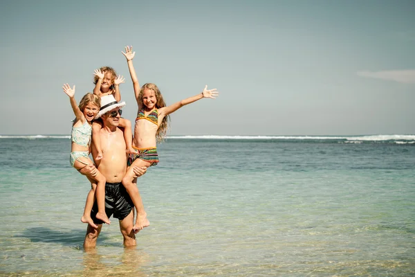 Famiglia felice che gioca sulla spiaggia durante il giorno — Foto Stock