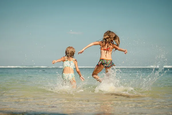 Two sisters playing on the beach at the day time — Stock Photo, Image