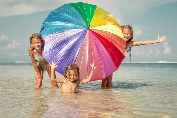 Glada barn som leker på stranden på dagarna — Stockfoto