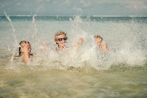 Famiglia felice che gioca sulla spiaggia durante il giorno — Foto Stock