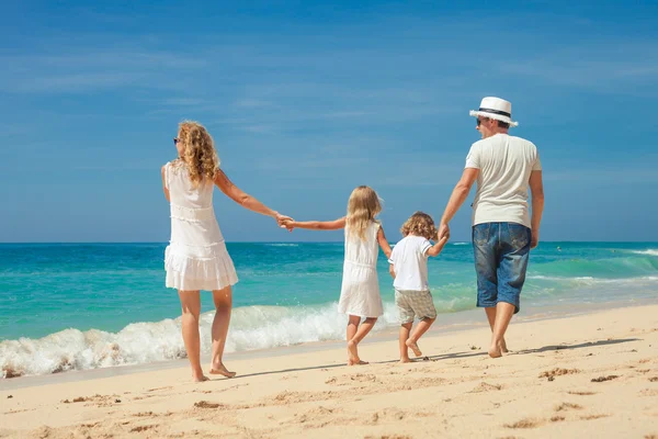 Familia feliz caminando por la playa durante el día . — Foto de Stock