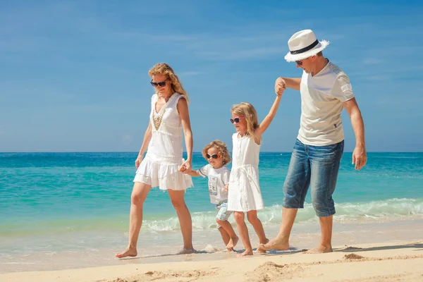 Gelukkige familie wandelen op het strand op het moment van de dag. — Stockfoto