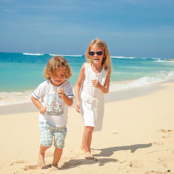 Bambini felici che giocano sulla spiaggia durante il giorno — Foto Stock