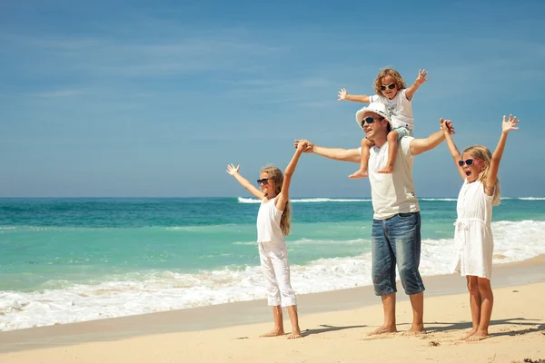 Gelukkige familie wandelen op het strand op het moment van de dag. — Stockfoto