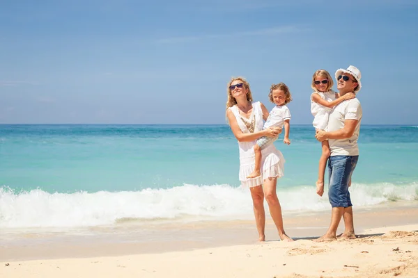 Lyckliga familjen promenerar på stranden på dagarna. — Stockfoto
