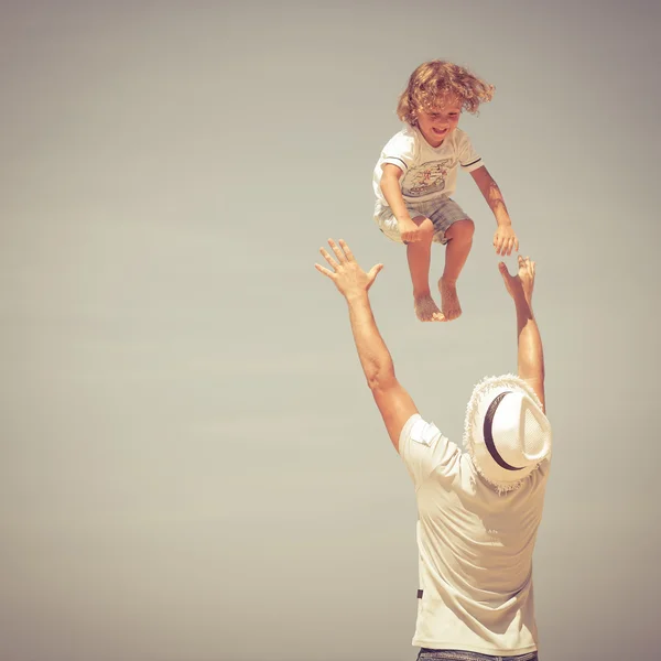 Padre e figlio che giocano sulla spiaggia durante il giorno — Foto Stock