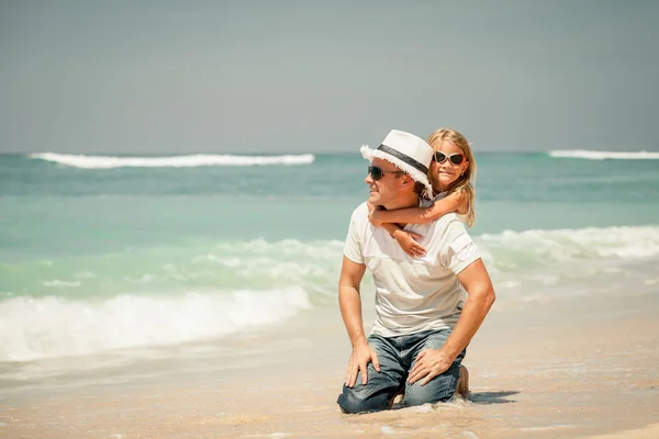 Pai e filha brincando na praia no dia — Fotografia de Stock