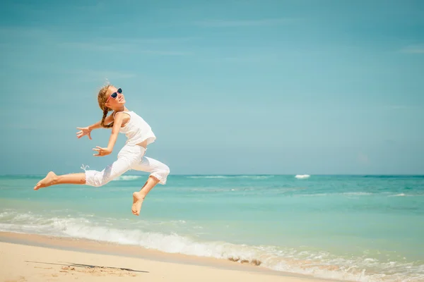 Teen girl  jumping on the beach at blue sea shore in summer vaca — Stock Photo, Image