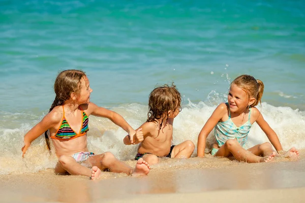 Crianças felizes brincando na praia na hora do dia — Fotografia de Stock