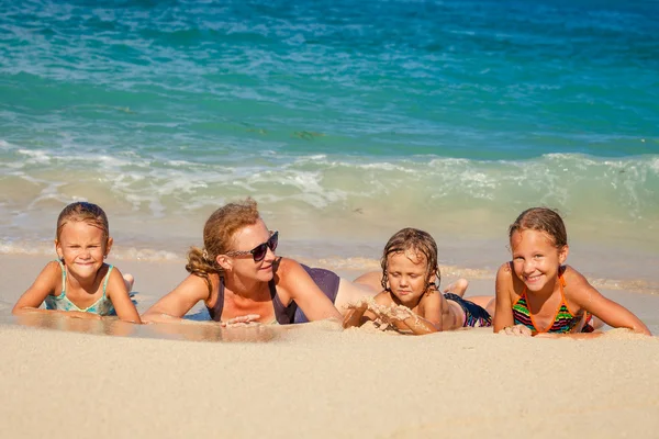 幸福的家庭，在白天的时间躺在海滩上 — 图库照片