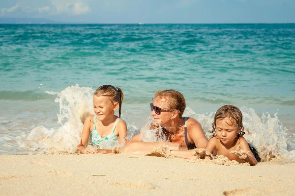 Liggend op het strand op het moment van de dag en gelukkige familie — Stockfoto