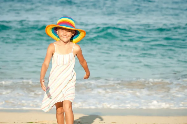 Klein meisje permanent op het strand op het moment van de dag — Stockfoto