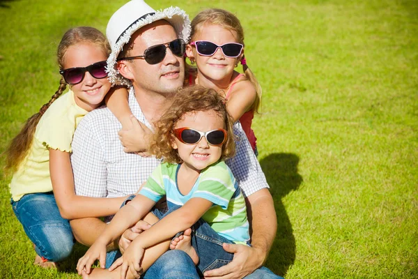 Bir mutlu aile çimenlerin üzerinde gün zaman oturma portre — Stok fotoğraf