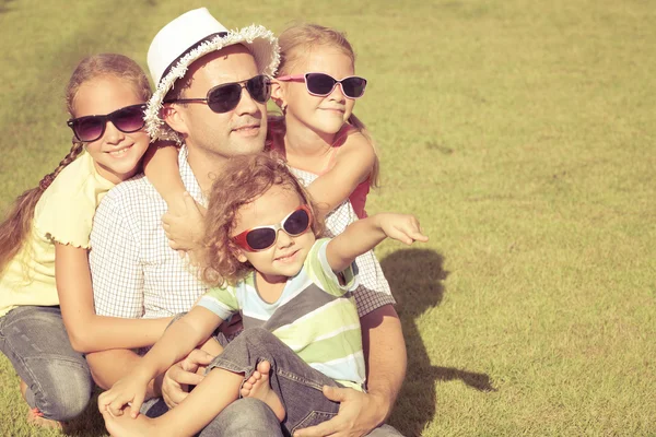 Portrait a happy family sitting on the grass at the day time — Stock Photo, Image