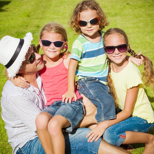 Portrait a happy family sitting on the grass at the day time — Stock Photo, Image