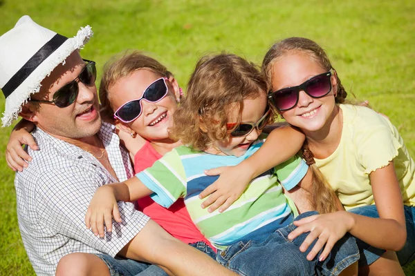 Portrait a happy family sitting on the grass at the day time — Stock Photo, Image