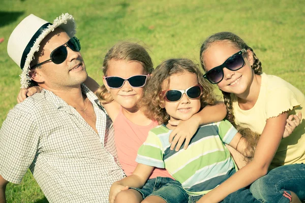 Retrato de uma família feliz sentado na grama na hora do dia — Fotografia de Stock