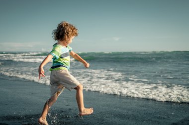 küçük çocuk kumsalda gün çalışıyor