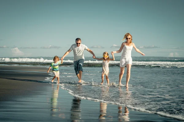 Lycklig familj spelar på stranden på dagarna — Stockfoto