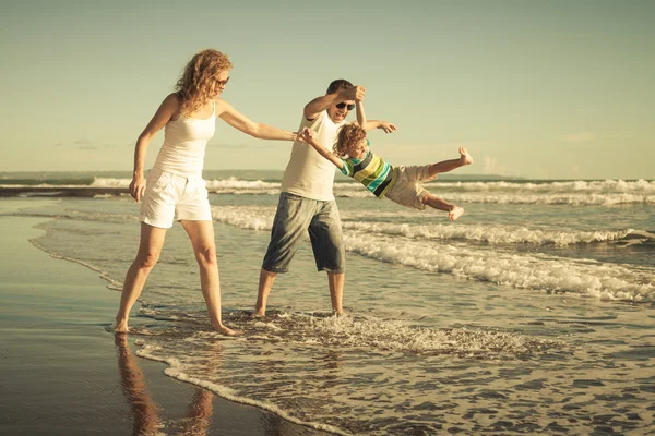 Famiglia felice che gioca sulla spiaggia durante il giorno — Foto Stock