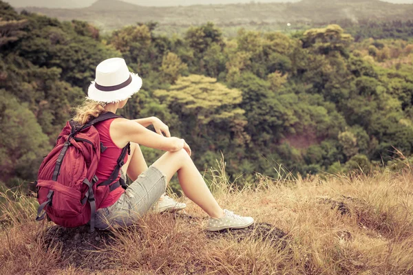 Turistické s batohem odpočinkem na skále a obdivoval se těší — Stockfoto