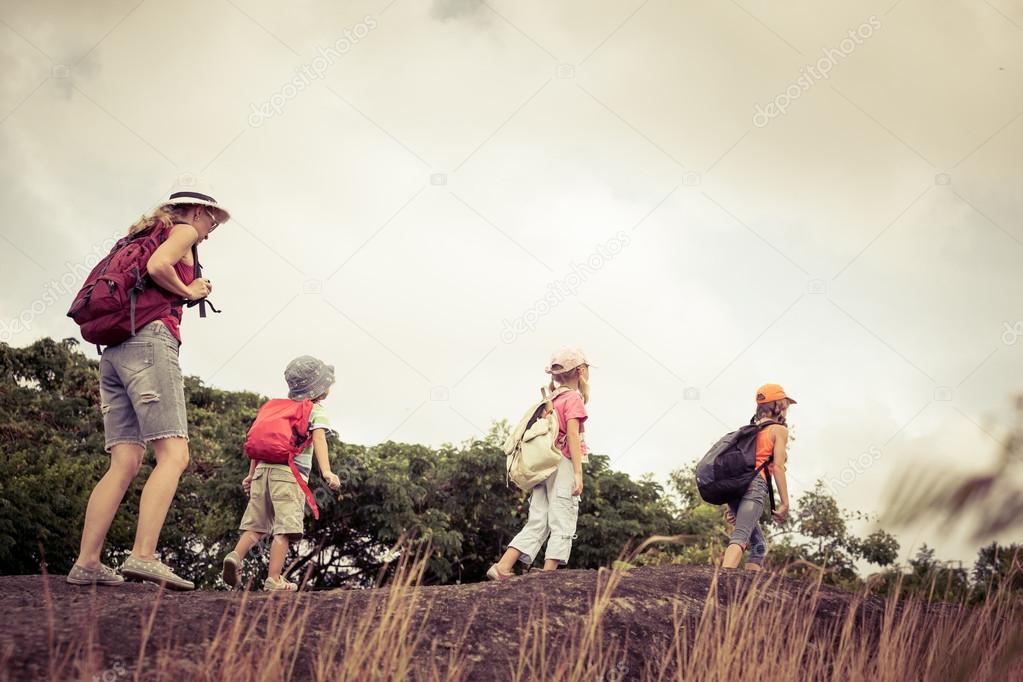 three little kids and mother in the mountains
