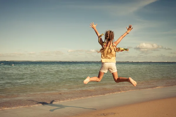 Teen flicka hoppning på stranden på dagarna — Stockfoto