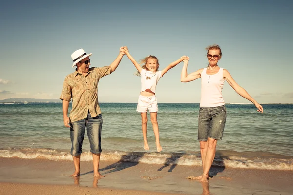 Glückliche Familie spazieren am Strand zur Tageszeit. — Stockfoto
