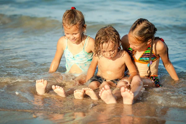 Glückliche Kinder spielen am Strand — Stockfoto