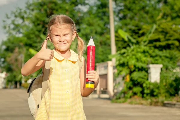 Glückliches Schulmädchen steht auf der Straße — Stockfoto