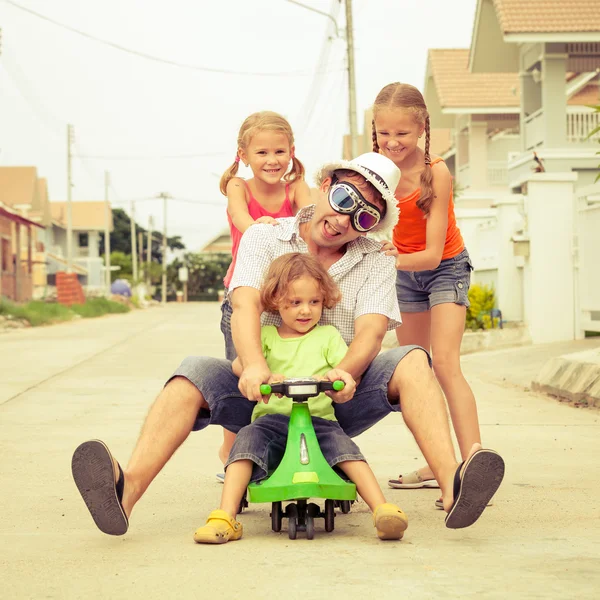 Pai e filhos brincando perto de uma casa no dia — Fotografia de Stock