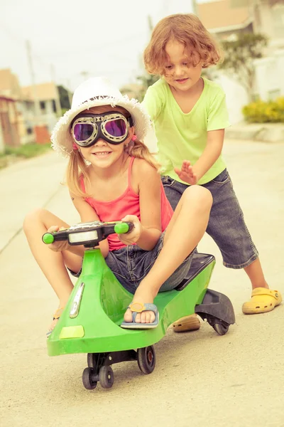 Niños felices jugando en la carretera durante el día — Foto de Stock