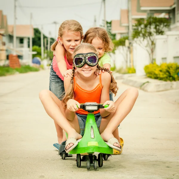 Tre bambini felici che giocano sulla strada durante il giorno — Foto Stock