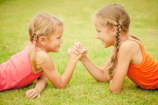 芝生で遊んで幸せの 2 人の姉妹の肖像画 — ストック写真