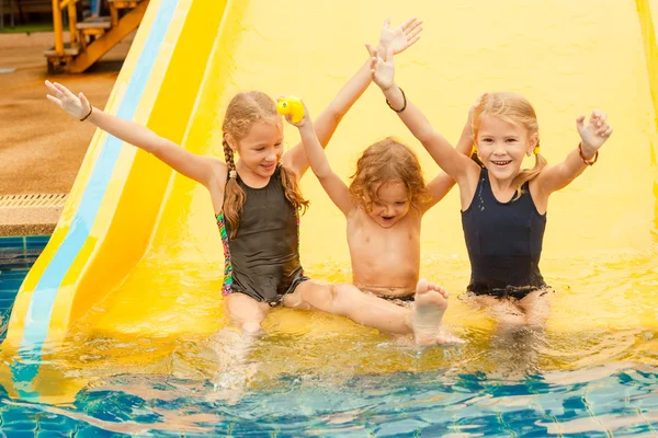 Three little kids playing in the swimming pool — Stock Photo, Image